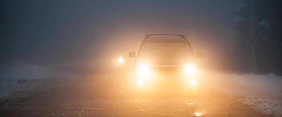 Car with bright headlights in snow